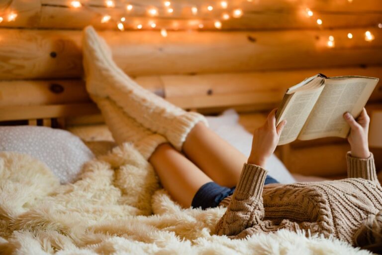 Junge Frau entspannt sich aufm Bett und liesst ein Buch