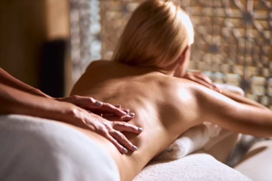 Escort model receiving back massage in wellness spa