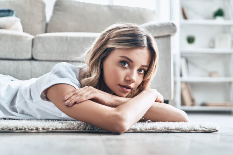 Blonde model laying on a carpet