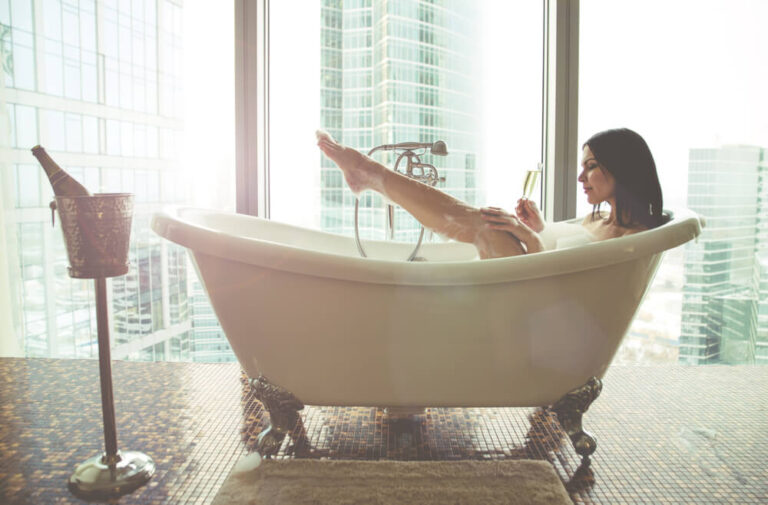 Woman in a bath drinking champagne